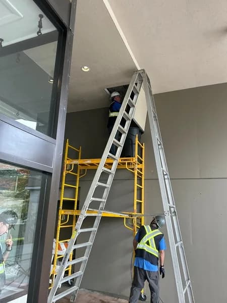 Technician working from elevated access equipment during drainage-stack service
