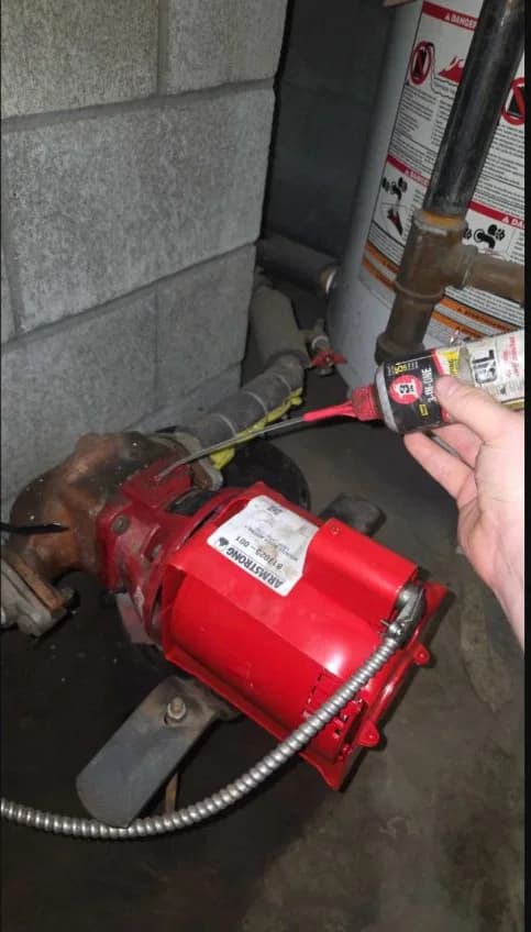 Technician lubricating a domestic hot-water recirculation pump