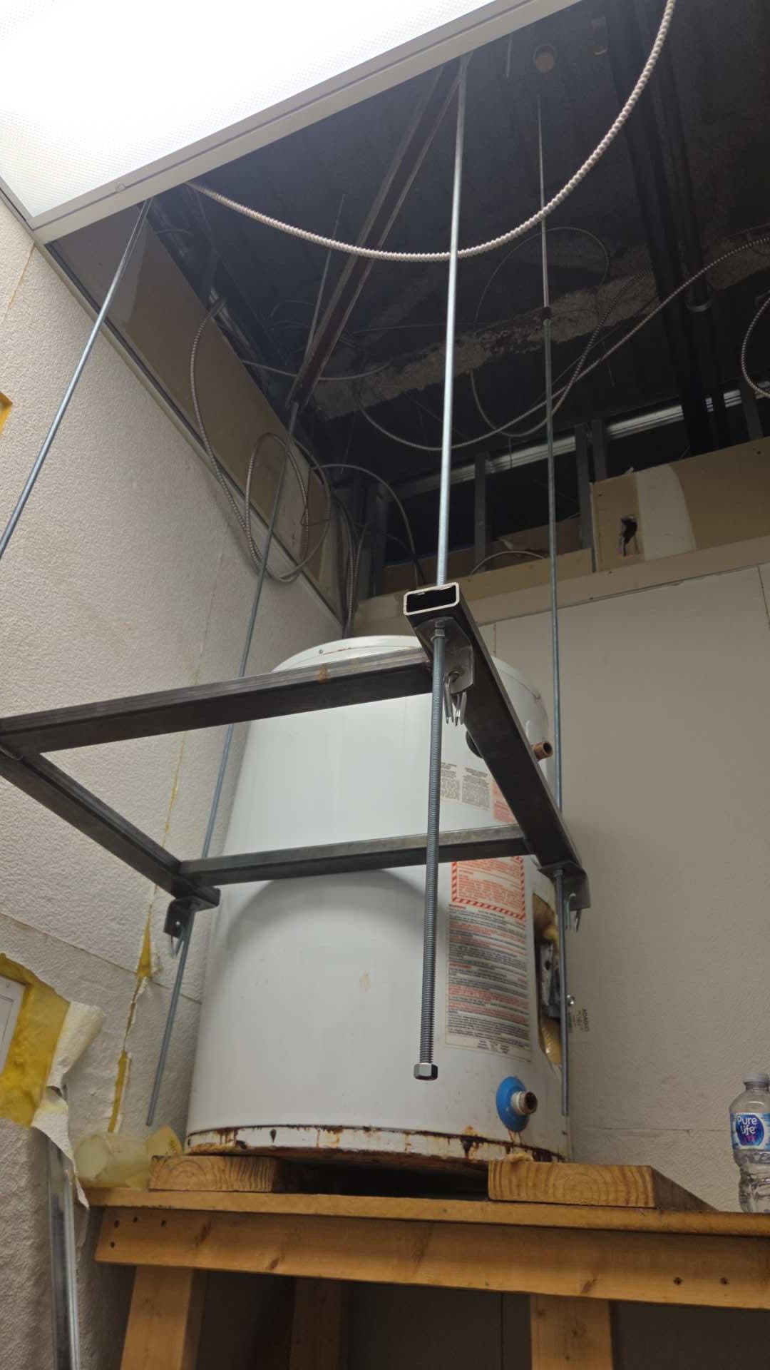 Old hot-water tank being lowered from a ceiling space