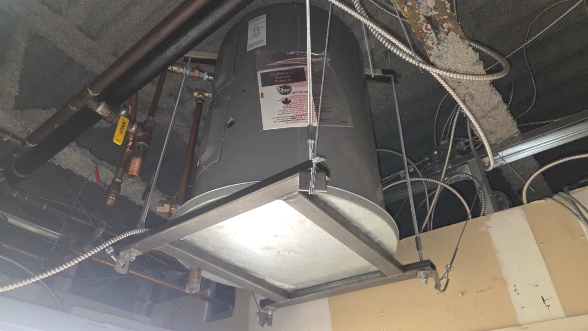 Replacement hot-water tank installed in a suspended ceiling space