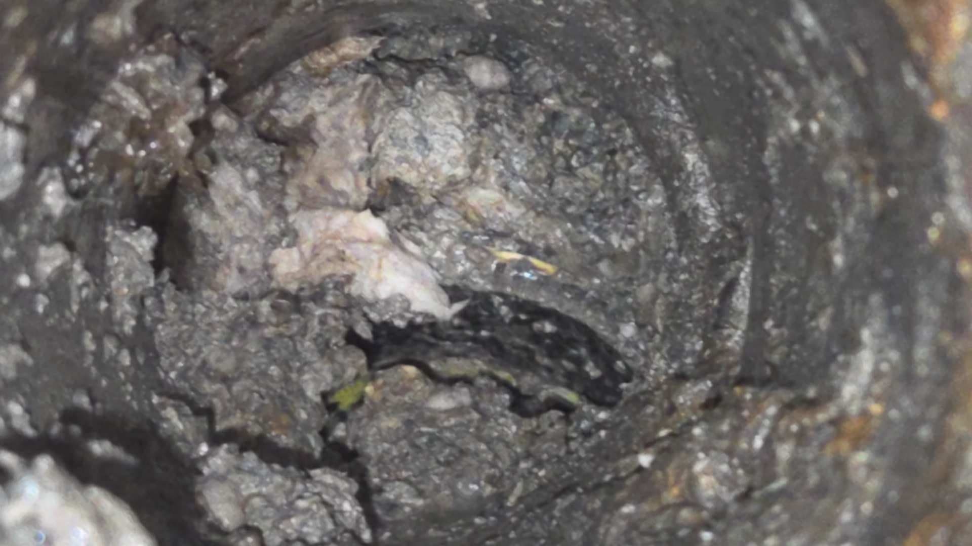 Drain interior showing loose gravel and a disrupted pipe route