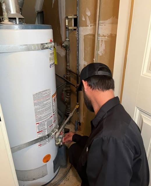 A technician servicing a residential water heater