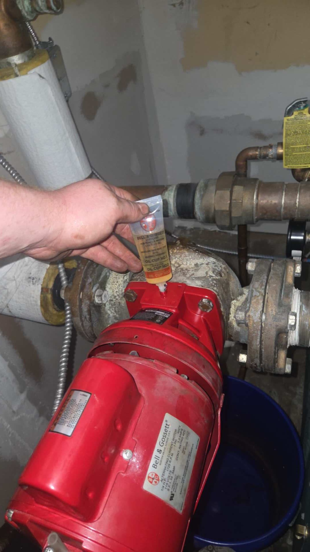 Reassembled red boiler circulation pump returned to its piping connections