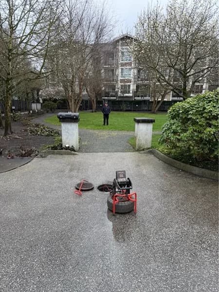 Drainage-service equipment positioned beside a multi-unit property