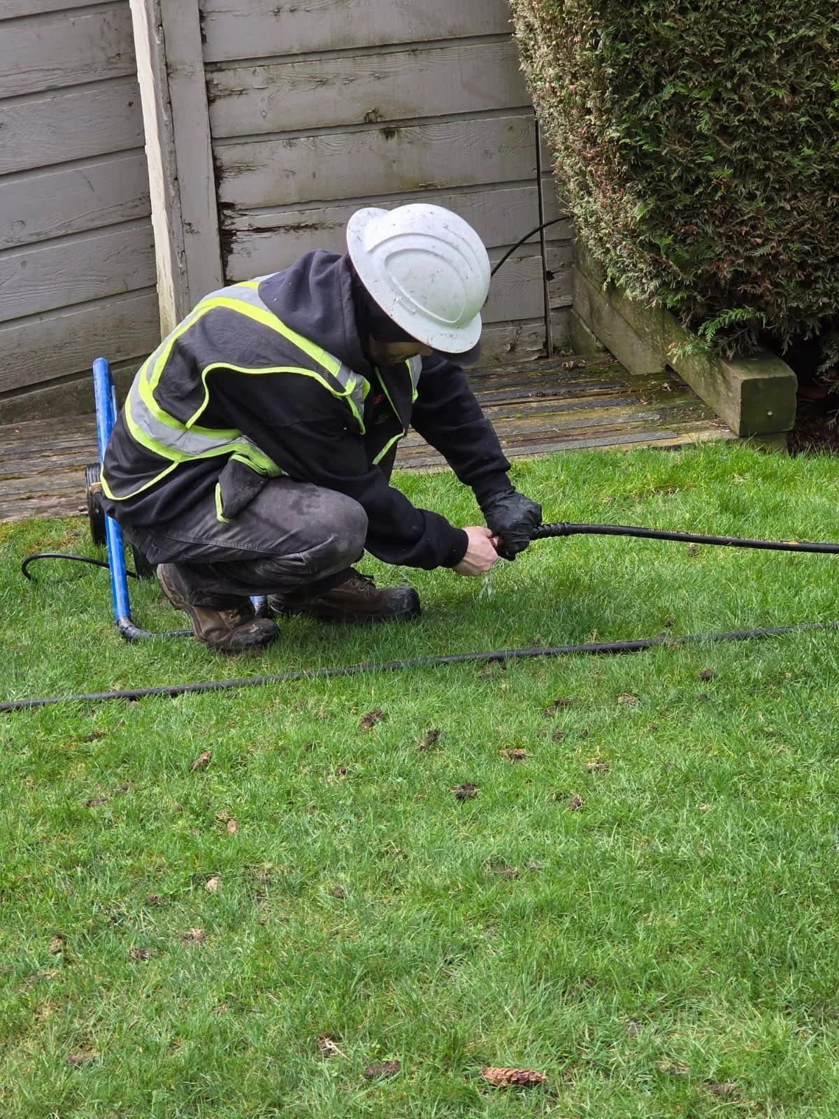 Technician using drain diagnostic equipment outside a home