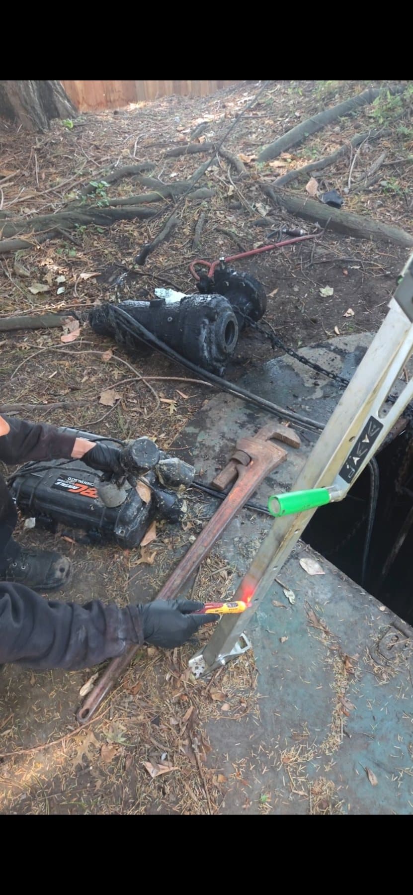 Removed sump pump beside an open vault during a field assessment