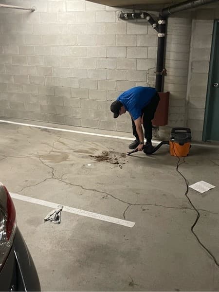 Technician completing cleanup after a parkade storm-drain repair