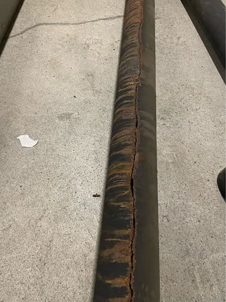 Cracked cast-iron storm drain section removed from a parkade repair