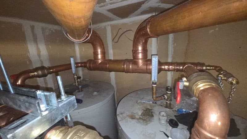 Completed copper manifold piping above domestic hot-water tanks