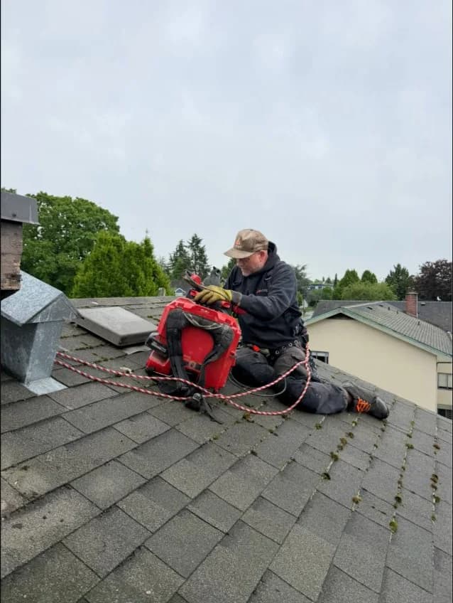 Technician cabling a roof vent stack with fall protection