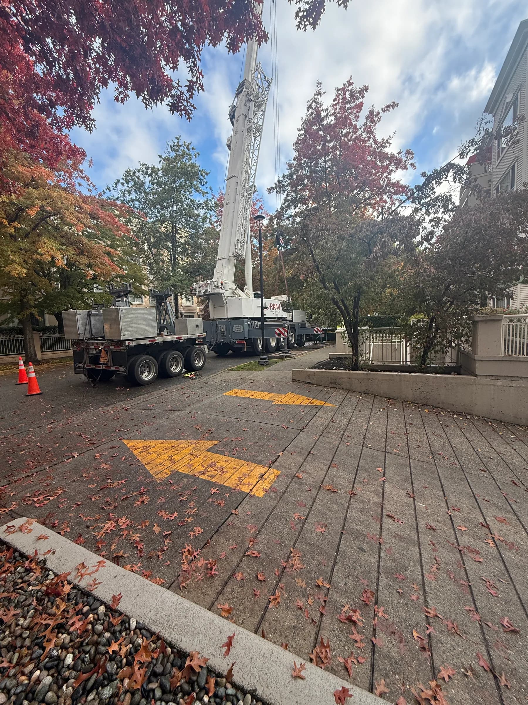Crane staged for rooftop mechanical work at a residential property
