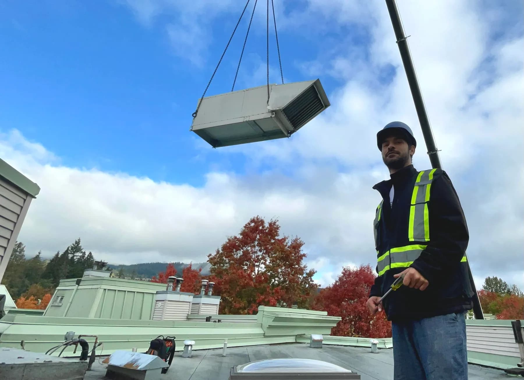 Rooftop mechanical equipment being positioned by crane