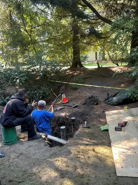 Exposed buried pipe and protected repair access during an active sewer excavation