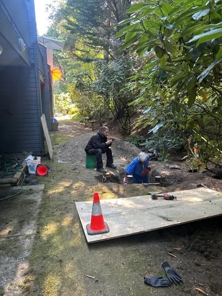 Protected targeted sewer excavation in progress beside a residential building