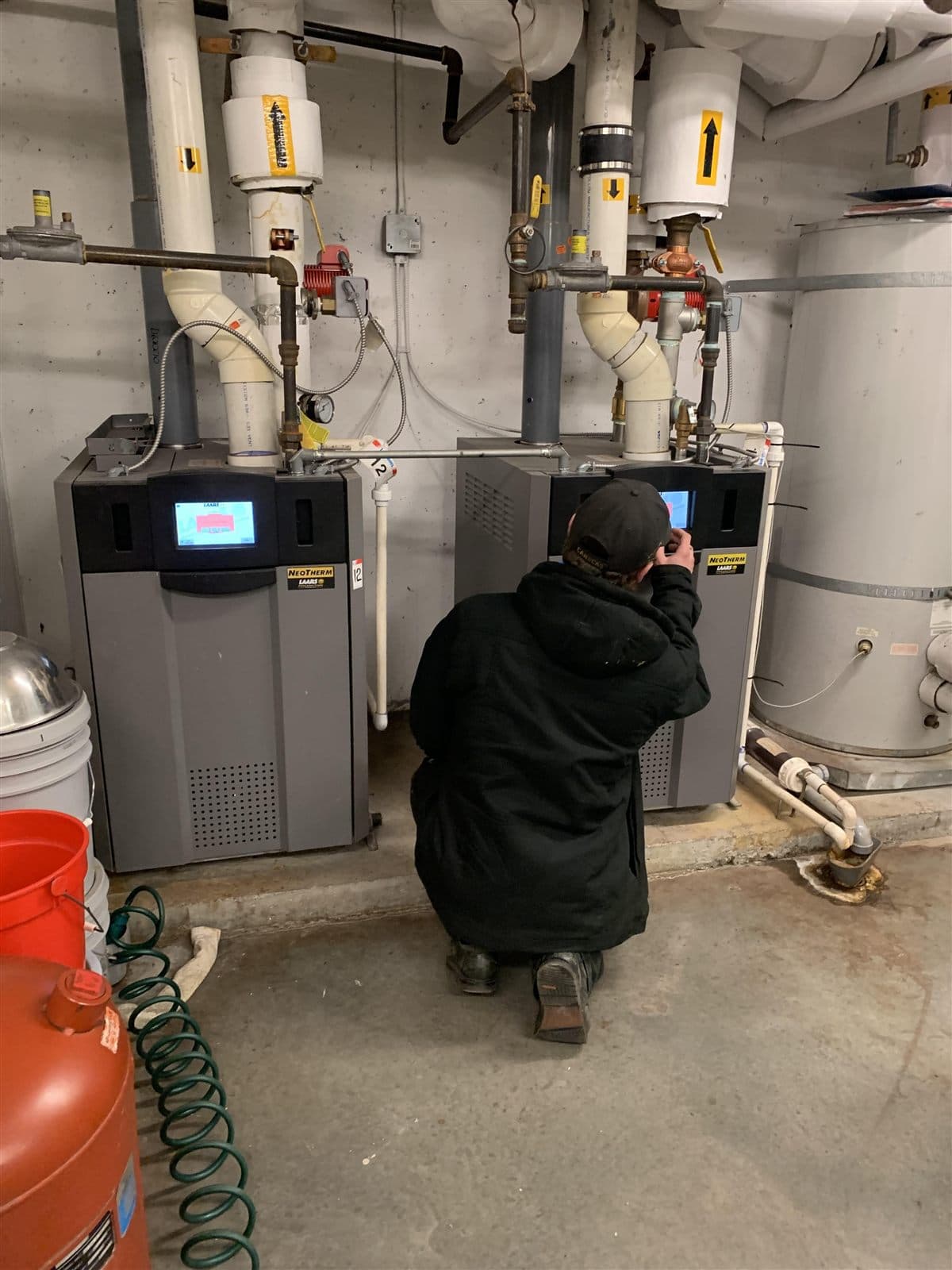 Technician assessing a multi-unit boiler system
