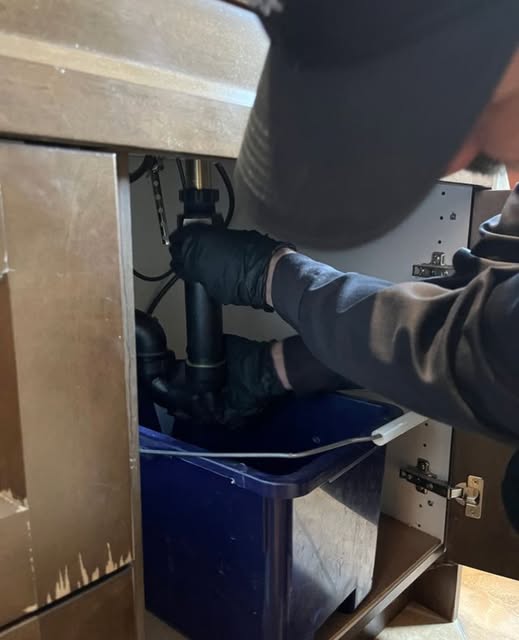 Under-sink plumbing service in progress